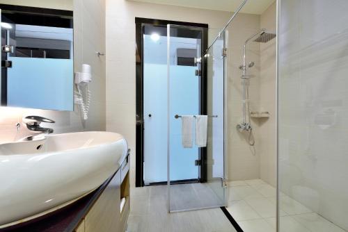 台中市台中新干线花园酒店的一间带水槽和玻璃淋浴的浴室