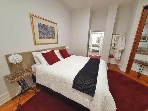 奥克兰Heritage 313 Auckland的一间卧室配有一张带红色枕头的大床