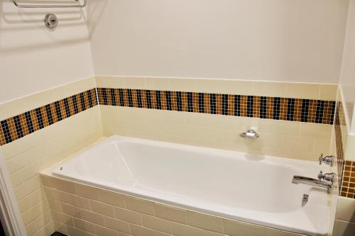 奥克兰Heritage 313 Auckland的瓷砖浴室设有白色浴缸。
