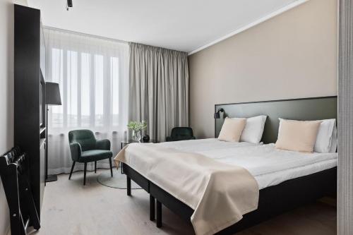 松兹瓦尔斯特兰德第一酒店的酒店客房带一张大床和一把椅子