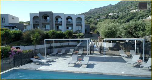 利勒鲁斯Résidence Roc e Mare的一座带桌椅的游泳池以及一座建筑