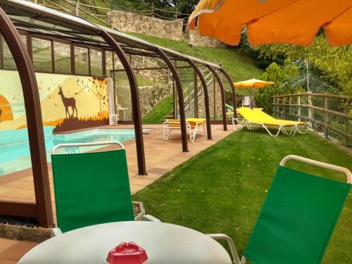 圣胡安-德拉斯阿巴德萨斯La Batllia的一个带游泳池和绿色椅子的花园