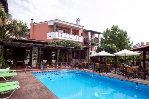 佩科霍里阿蒙花园酒店的一座带房子的建筑前的游泳池