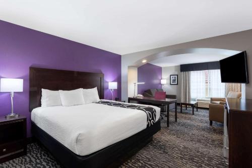 麦迪逊亨茨维尔机场麦迪逊拉昆塔套房酒店的酒店客房设有一张大床和一张书桌。