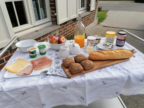 霍尔斯贝克B&B Leybeeckhof的餐桌,早餐包括面包、肉类和奶酪