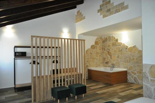 布里韦加Hostal Restaurante Villa de Brihuega的一间带浴缸的浴室,位于石墙的房间内