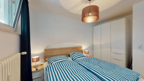 万根沃格Seeluft 34 - Wangerooge的一间卧室配有一张蓝色和白色条纹的床