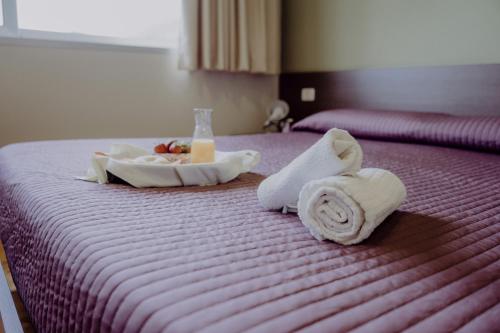 卡斯特拉巴特滨海Tocchi di Puglia的一间酒店客房,配有毛巾和床上的食品托盘
