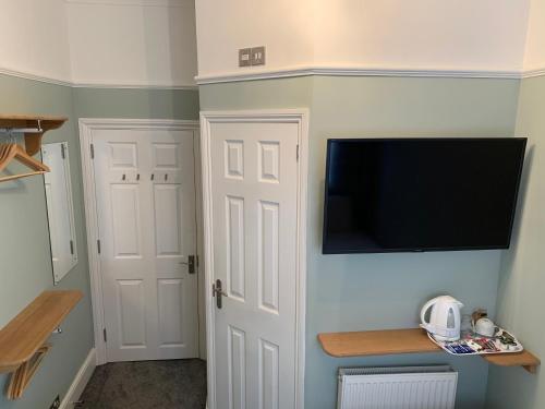 南安普敦Rivendell Guest House的一间房间,墙上设有电视,门