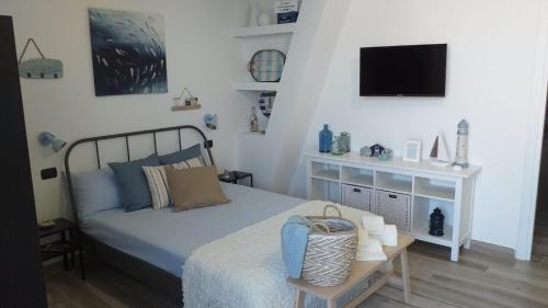 切法卢La Casetta di Laura的卧室配有一张床,墙上配有电视。