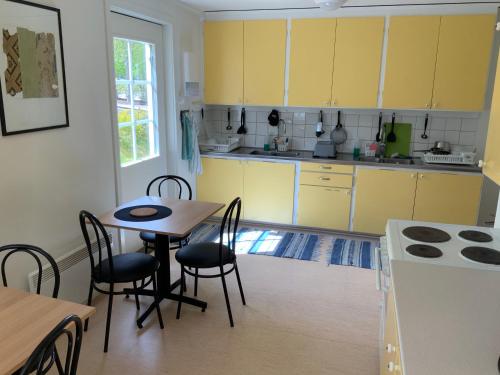 韦克舍Evedals Vandrarhem Växjö的厨房配有黄色橱柜和桌椅