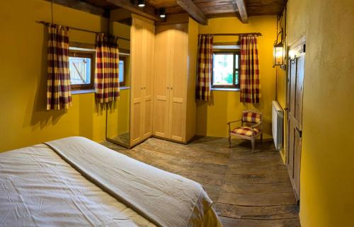 Los Espejos de la ReinaCasa Rural La Costurera的卧室拥有黄色的墙壁,配有一张床和椅子