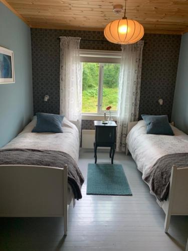 Hjartdal诺布彭约纳特酒店的一间卧室设有两张床,其中设有窗户。