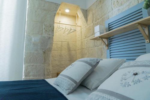 特拉尼Donato Rooms的一间卧室配有一张石墙床