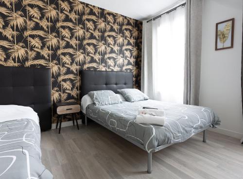 巴黎Hotel Europe BLV的一间卧室配有一张黑色和金色壁纸的床