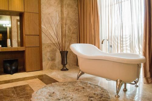 巴伦西亚Hesperia WTC Valencia的带浴缸和花瓶的浴室