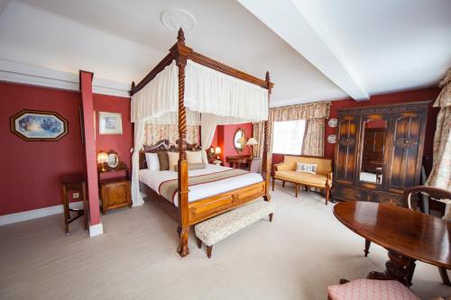 阿斯顿尖塔霍尔特酒店的一间卧室配有一张天蓬床和一张桌子
