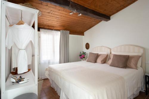 阿雷佐Scacciapensieri Guest House的卧室设有白色的床和木制天花板。
