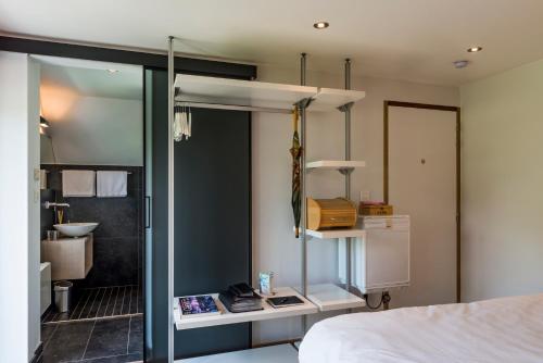 Heusden希尔安努B&B旅馆的一间卧室配有一张床,浴室设有水槽