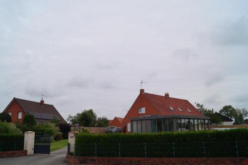 AudruicqÀ La Maison Du Bonheur的院子里有红色屋顶的房子