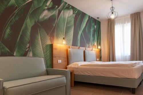 托尔博莱epOche Hotel Zanella 1889的一间卧室配有一张带大壁画叶子的床