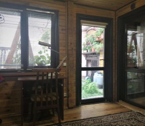 基辅Деревянный 2-х комнатный домик的客房设有2扇窗户和1把木椅。