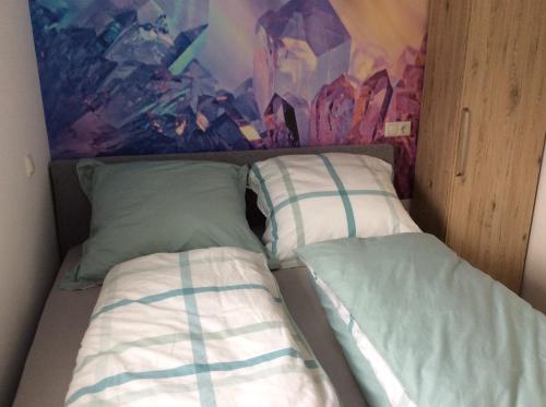 施莱登Fewo Eifeler Edelsteine „Aquamarin“的一张带两个枕头的床