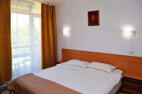 维纳斯桑达酒店的一间卧室设有一张床和一个大窗户