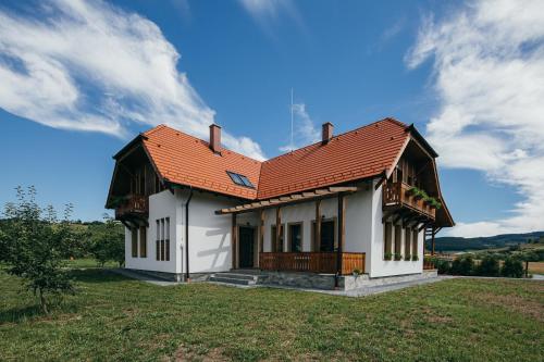 普拉伊德Hygge Praid的一座白色的房子,在田野上有一个橙色的屋顶