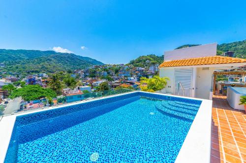 巴亚尔塔港Tres Marias Luxury Suites - Adults Only的一座位于美景房屋屋顶的游泳池