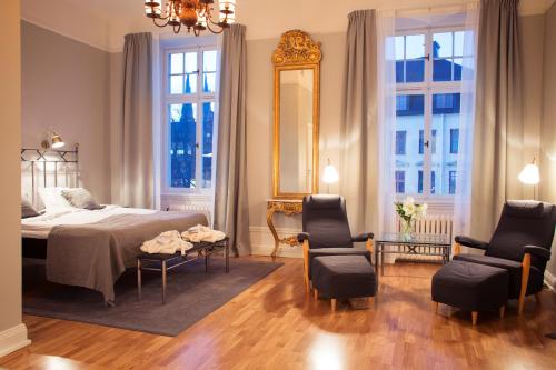 乌普萨拉霍恩格兰德酒店的一间卧室配有一张床、两把椅子和镜子