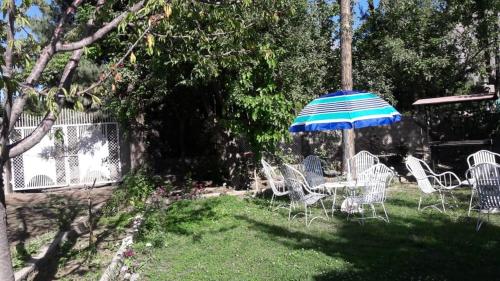 TandalRafsal The Guest House的院子里的一组椅子和一把伞
