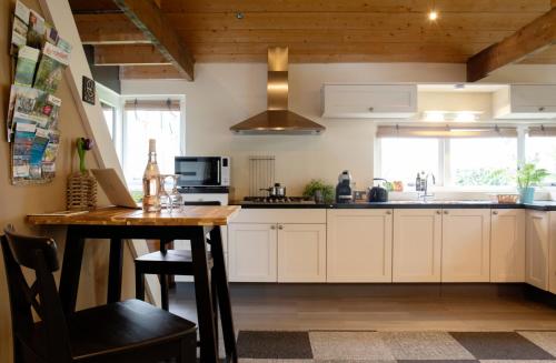 Winterswijk HenxelBuitenverblijf Het Grootenhuis的厨房配有白色橱柜和木桌