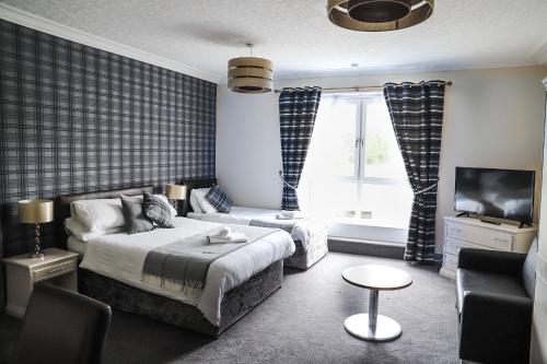 因弗鲁里亚德南宾馆的一间卧室配有一张床、一张沙发和一台电视。