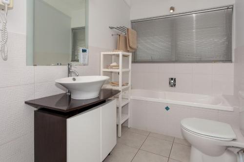 旺阿马塔太平洋棕榈汽车旅馆的白色的浴室设有水槽和卫生间。
