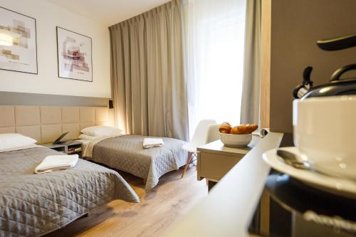 华沙Wolska Residence的酒店客房设有两张床和一张桌子。