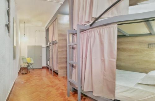 里斯本Draft Hostel & Rooms的客房设有两张双层床,铺有木地板。
