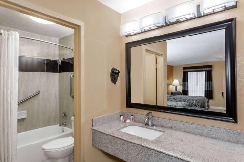 萨拉索塔萨拉索塔湾戴斯酒店的一间带水槽、卫生间和镜子的浴室