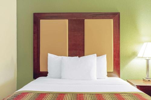 朗克斯兰卡斯特拉金塔旅馆及套房酒店的一张位于酒店客房内的木床头板床