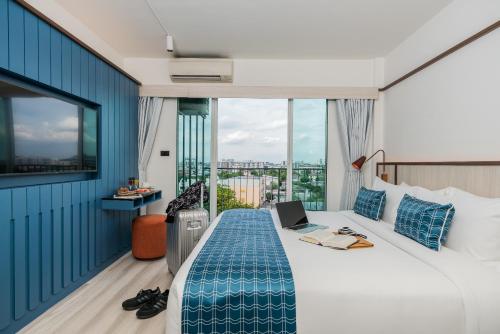 曼谷Hotel Amber Sukhumvit 85的酒店客房,配有一张带笔记本电脑的床