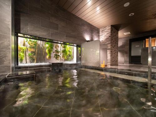 别府Super Hotel Beppu Ekimae的室内游泳池,位于带游泳池的房子内