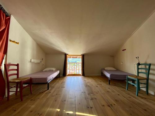 圣让皮耶德波尔Gite de la Porte Saint Jacques: a hostel for pilgrims的阁楼间 - 带两张床和椅子
