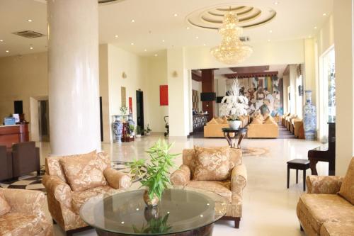 槟知越南Uc酒店的大厅,在大楼里配有沙发和桌子