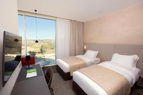 阿尔及尔阿尔及尔假日酒店 - 凯拉加塔的酒店客房设有两张床、一张书桌和一个窗户。