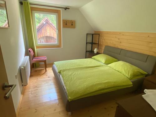 戈德马图杰克Sobe v Gozdu的一间卧室设有一张绿色的床和一个窗户。