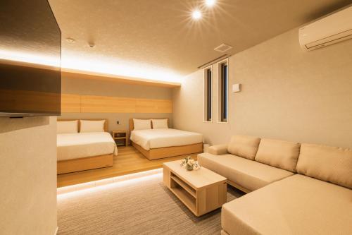 福冈GRAND BASE Hakata Station的一间带两张床和一张沙发的客厅