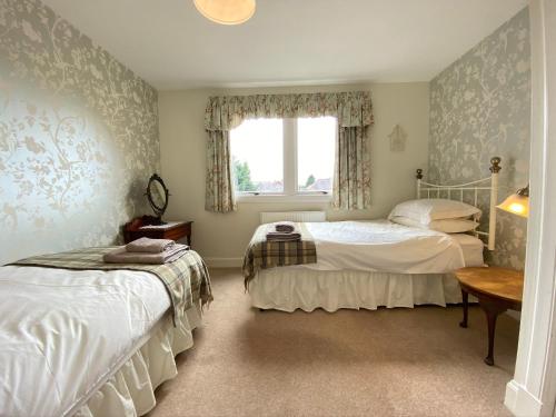 爱丁堡St Margaret's Cottage, Edinburgh的一间卧室设有两张床和窗户。