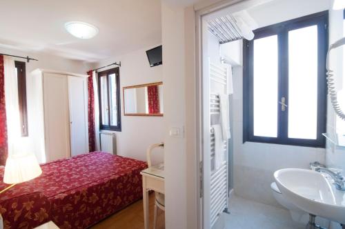 威尼斯托伦蒂尼小客栈的一间带床、水槽和水槽的小浴室