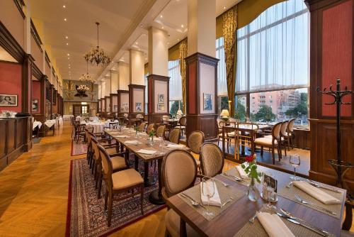 布拉迪斯拉发阿波罗布拉迪斯拉发大酒店的餐厅设有桌椅和大窗户。