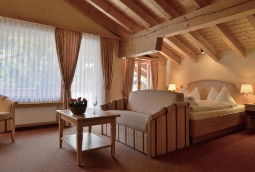 克洛斯特斯斯尔瑞特塔公园酒店的一间卧室配有一张床、一张沙发和一张桌子
